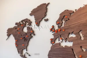 Orange magnetic pins installed on a Walnut wooden world map