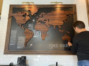 Coffee beans are pinned on a magnetic Rosewood world map