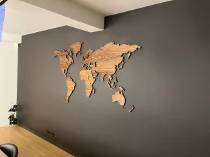 American Walnut world map installed on a black wall - side view