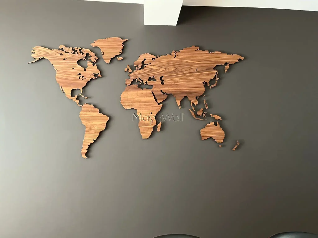 The American Walnut wooden world map installed on a black wall with pin-magnets